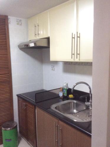 a kitchen with a sink and white cabinets at Condo at Parkside Villas across the airport in Manila