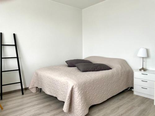 a white bedroom with a bed with two pillows on it at Centerpoint Imatra in Imatra