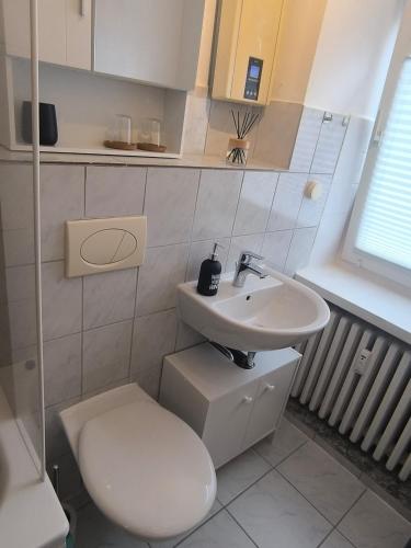 a white bathroom with a toilet and a sink at BR Apartment in Kiel