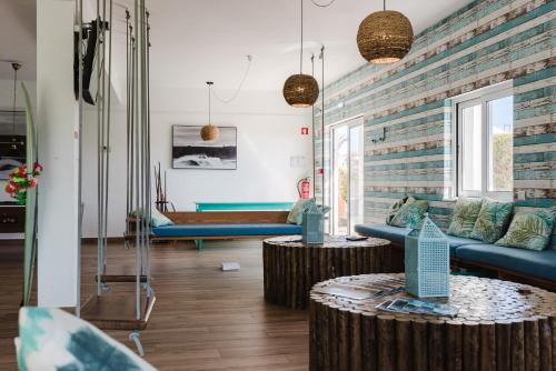 a living room with two blue couches and two tables at Sagres Natura in Sagres