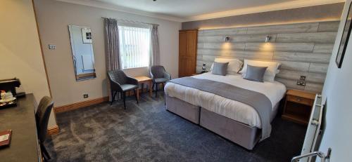 a hotel room with a bed and a table and chairs at The Royal Hotel in Liverpool