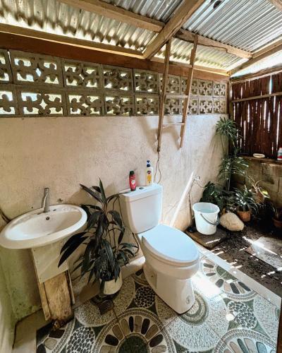 a bathroom with a toilet and a sink at Cabin Camping at Balay Hilway in Sara