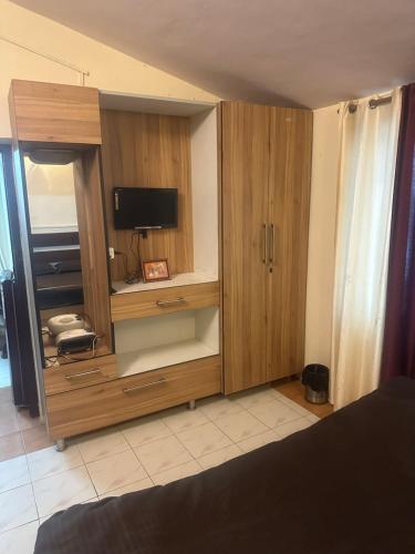 a large wooden cabinet with a television in it at Peaceful Pines Cottage in Bhowāli