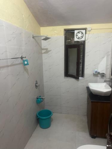 a bathroom with a sink and a clock on the wall at Peaceful Pines Cottage in Bhowāli
