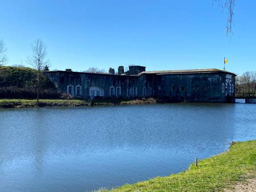an old building sitting next to a body of water at Erflogies Fort Liezele in Puursheide