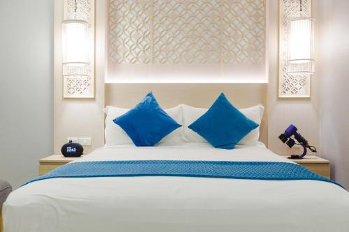 a bedroom with a large bed with blue pillows at Kamala Havana Hotel and Cafe in Kamala Beach