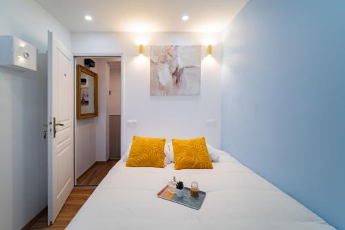 a bedroom with a white bed with yellow pillows at Paris - Blue Sky Homestay in Le Kremlin-Bicêtre