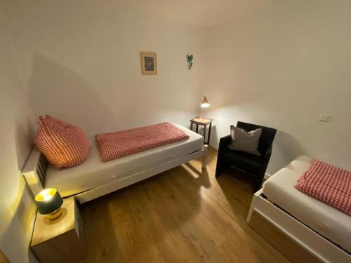 a room with two beds and a chair in it at Ferienwohnung Eberhard in Schwäbisch Gmünd