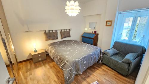 a bedroom with a bed and a chair and a chandelier at Casa Bomba in San Mauro Torinese