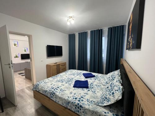 a bedroom with a bed with blue sheets and a television at marius in Chiajna