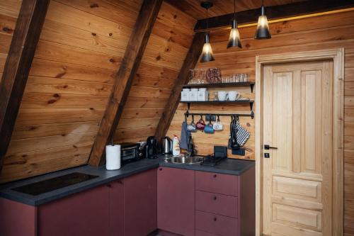 ジャブリャクにあるPeaksView Chaletsの木製の壁と木製のドアのあるキッチン