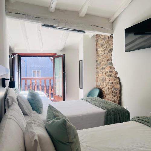 a hotel room with two beds and a balcony at Casa Briz in Ojedo