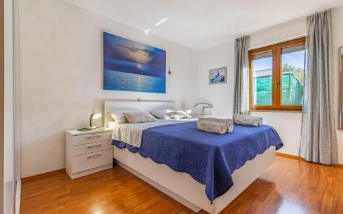 a bedroom with a large bed with a blue blanket at Good choice in Valbandon