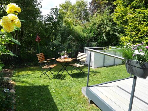a garden with two chairs and a table in the grass at Landhaus SoonZauber - Exklusives Paar-Hideaway im Naturpark Soonwald-Nahe in Münchwald