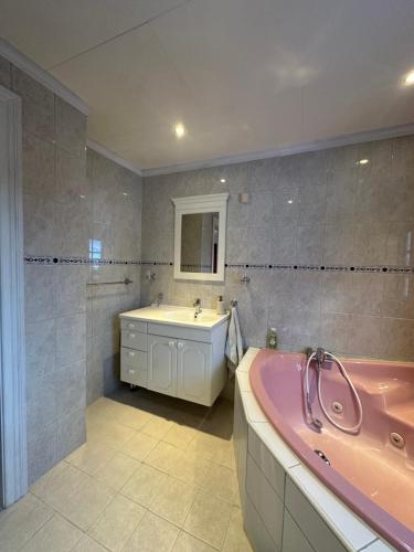 a bathroom with a pink tub and a sink at Familievennlig fritidsbolig i hjertet av Flå, perfekt for besøk i Bjørneparken in Flå