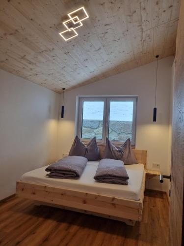 a bedroom with a bed with pillows on it at Ferienwohnung Kogler Zillertal in Fügenberg