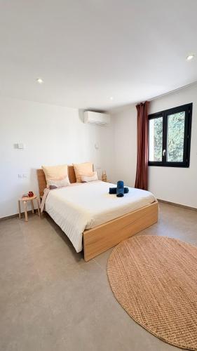 a bedroom with a large bed and a large window at Les Oliviers climatisés parking recharge électrique in Arles