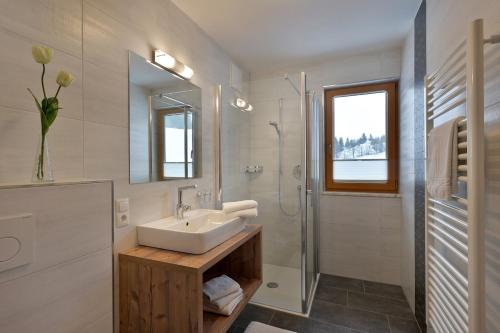 a white bathroom with a sink and a shower at Bauernhof Großwolfing- Appartementhaus Fischbacher in Ebbs