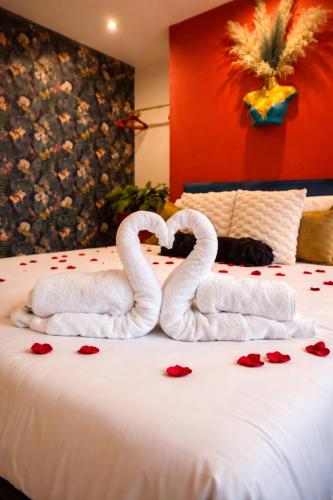 two towel swans sitting on top of a bed with roses at The Bunkhouse in South Shields