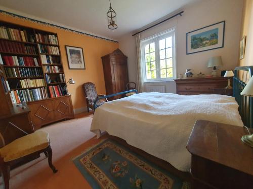 a bedroom with a bed and bookshelves at Mer et Style au coeur de l'éventail 3 pièces 2 chambres in Cabourg