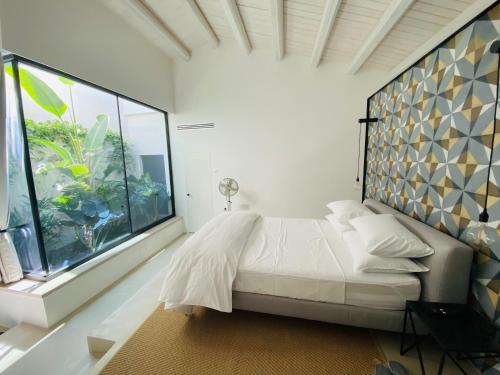 a bedroom with a bed and a large window at Tantillo Cinque in Modica