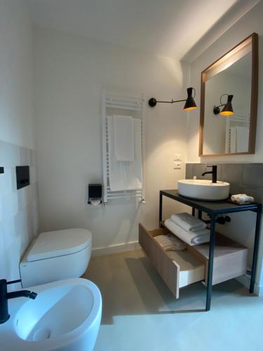 a bathroom with a toilet and a sink and a mirror at Tantillo Cinque in Modica