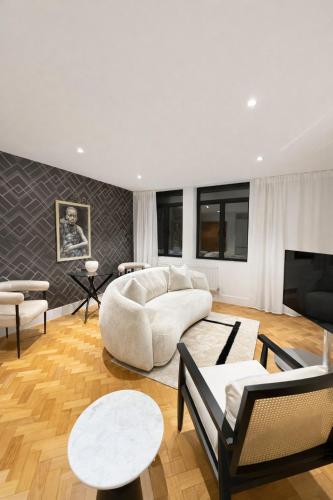 a living room with a white couch and chairs at Luxurious City Centre Apartment in Chelmsford with Sky TV, Sports, Movies & Netflix in Chelmsford