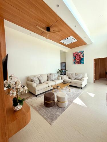 a living room with a couch and a table at Chareen Pool Villa in Ban Khlong Haeng