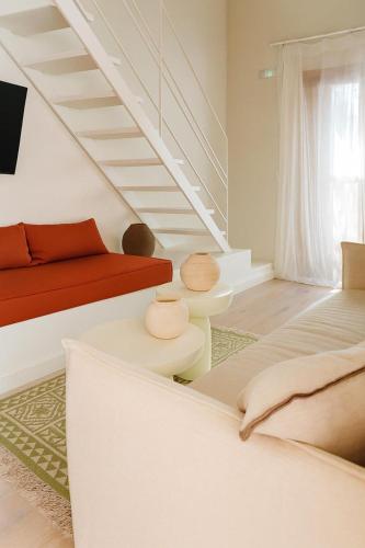 a living room with a couch and a staircase at The Village by WPS in Pollonia