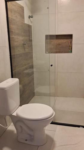a bathroom with a toilet and a glass shower at Caminho do Paraíso in Porto De Galinhas