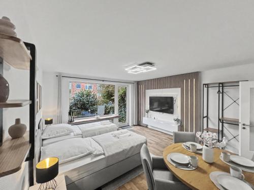 a bedroom with a bed and a table and a dining room at charmantes Apartment bei Hamburg - Ruhe, Komfort & kostenloses Parken in Rellingen