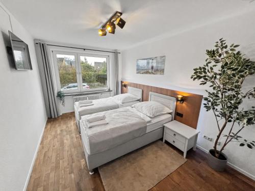 a bedroom with a bed and a potted plant at charmantes Apartment bei Hamburg - Ruhe, Komfort & kostenloses Parken in Rellingen