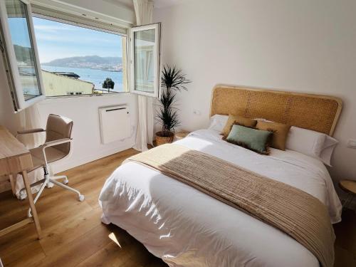 a bedroom with a large bed with a large window at RÍA LIVING - Calma 02 in Cee