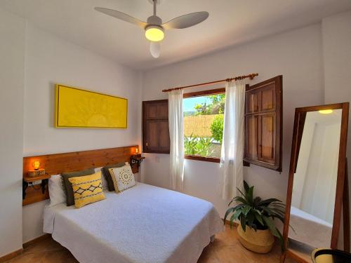 a bedroom with a bed with a ceiling fan and a window at Villa Florida in Motril