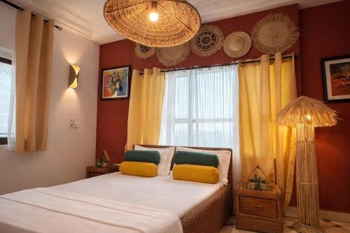 a bedroom with a bed with yellow and green pillows at Kaz An Nou in Cotonou