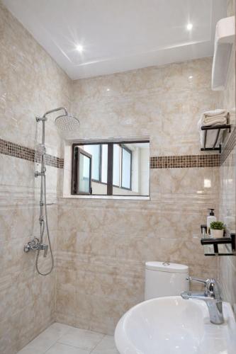 a bathroom with a sink and a toilet and a window at Kaz An Nou in Cotonou
