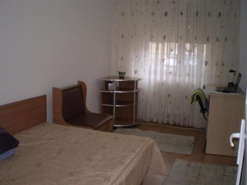 a bedroom with a bed and a chair and a window at apartament MIHAI in Mangalia