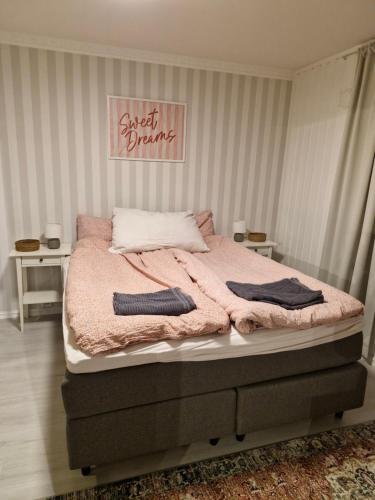 a bedroom with a bed with a pink blanket at Leilighet sentralt i Tromsdalen in Trondalen