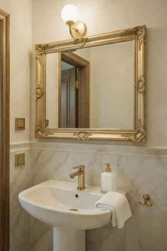 a bathroom with a sink and a mirror at Apartamenty PETRA Supraśl in Supraśl