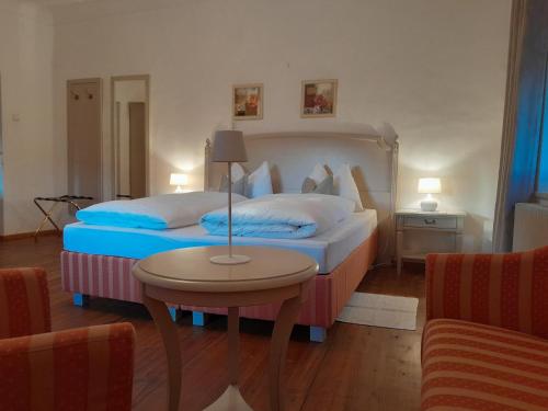 a hotel room with two beds and a table at Ansitz Strengherrnhof in Caldaro