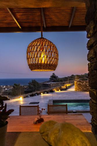 a chandelier hanging over a deck with a view of the ocean at Marilias cycladic home in Agios Fokas