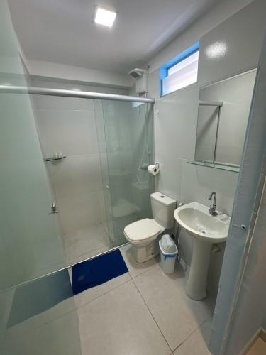 a bathroom with a shower and a toilet and a sink at Pousada Encantos do Mar in Barra de Camaratuba