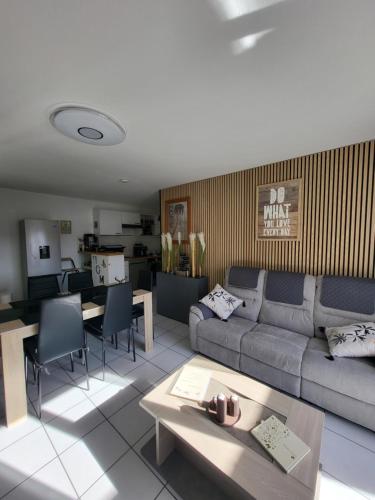 a living room with a couch and a table at Le Colibri in Fenouillet