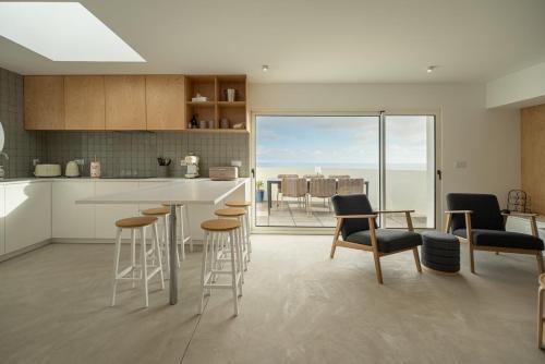 a kitchen with bar stools and a kitchen with a view at The Lookout | Private Beach Access in São Roque