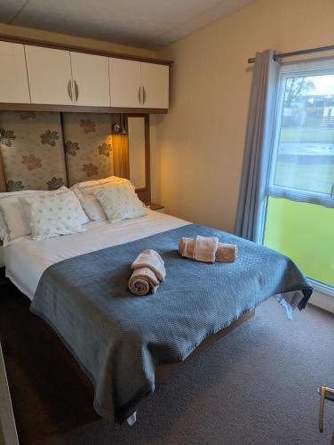 a bedroom with a bed with two towels on it at Loch's Heaven 67 in Kirkcowan