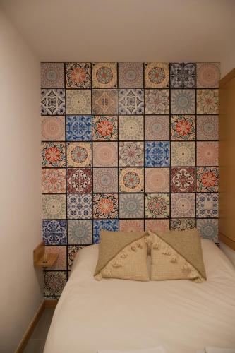 a room with a bed with a wall with tiles at VIELA Guest House T1 in Barcelos