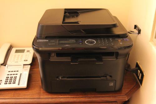a pile of printers sitting on a table next to a telephone at Hotel Pallotta in Assisi