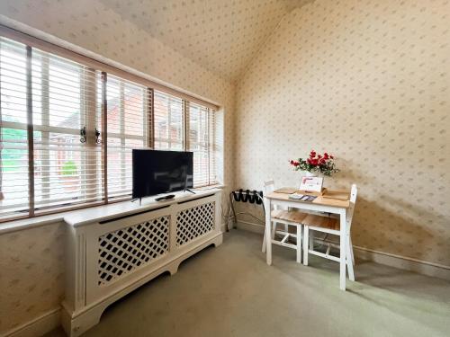 a living room with a tv and a table and a window at Cottage 1 - Uk46611 in Broughton
