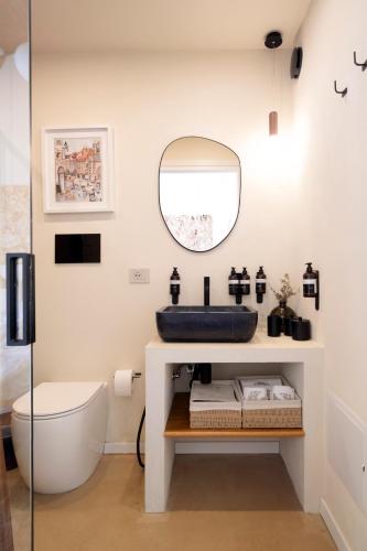 a bathroom with a sink and a toilet and a mirror at La Dimora del Pensatore - country escape Noto in Canicattini Bagni