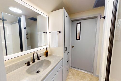 a bathroom with a sink and a mirror at Shore Pine Cottage in Grayland